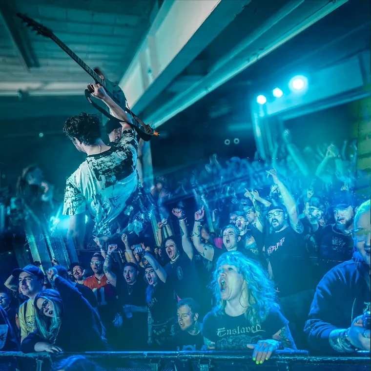 Waterlines playing live to a packed room under blue light